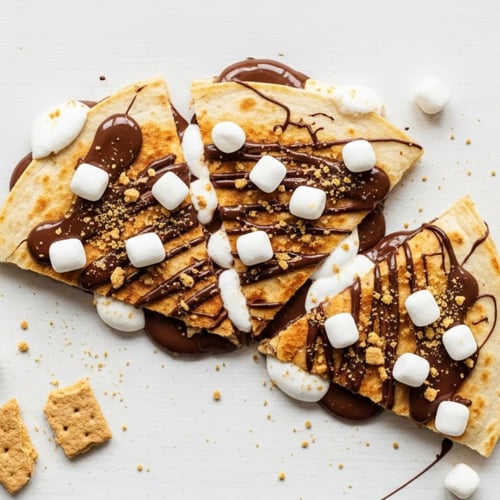 S'mores Quesadilla cut into triangles on a white wooden table close up.