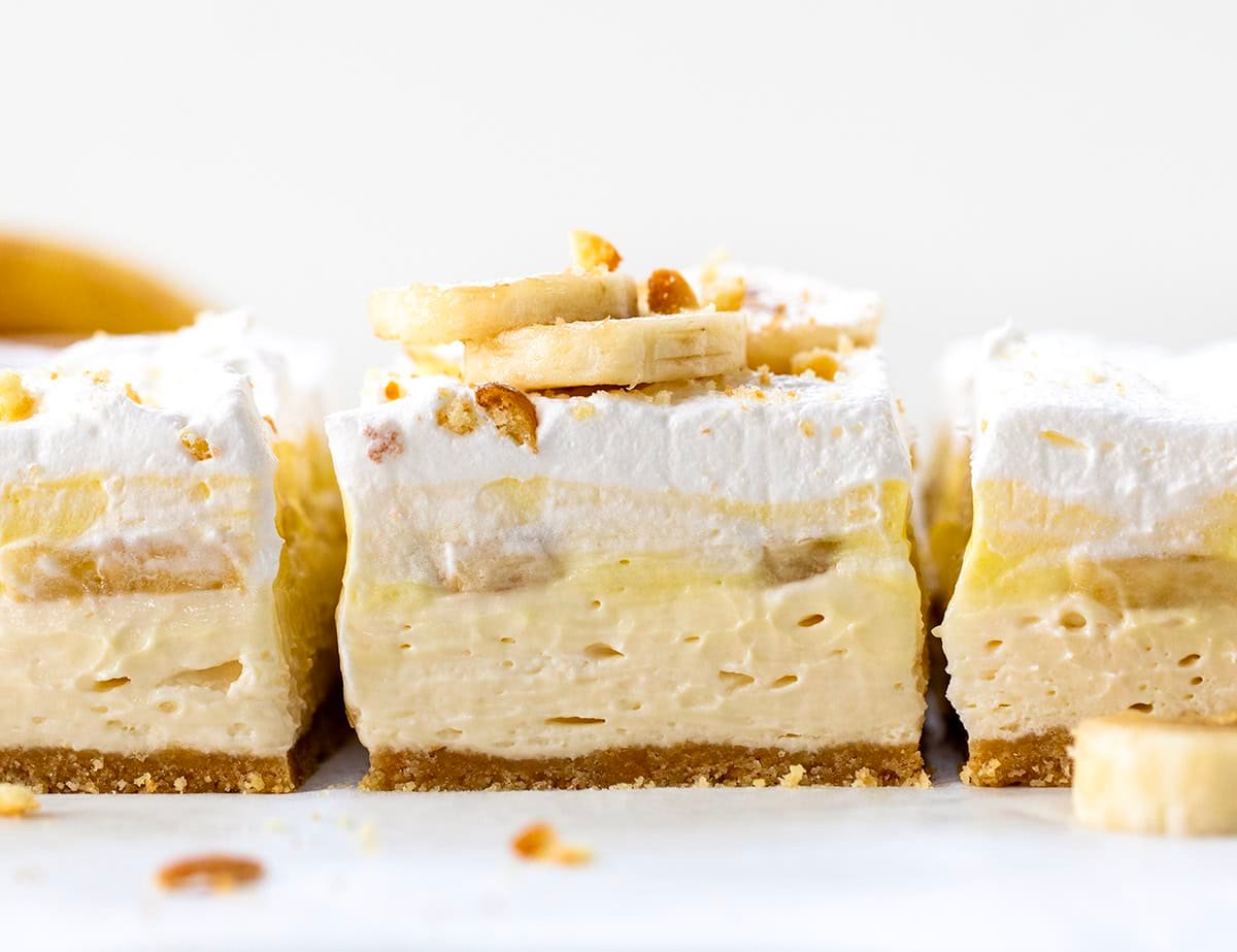 Banana Cream Pie Bars cut into squares on a white counter very close up.