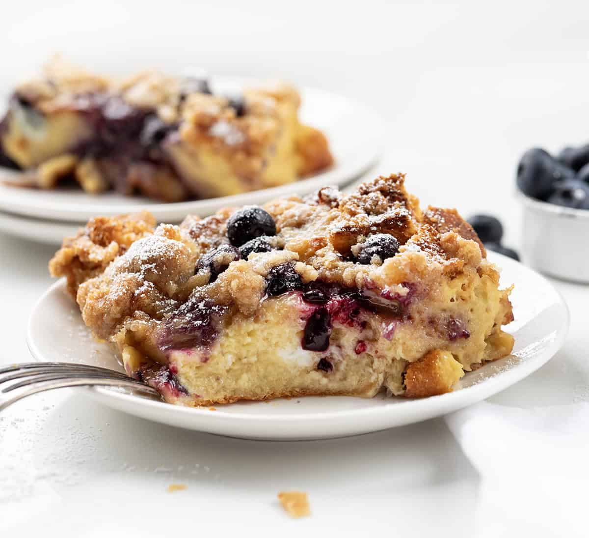 Blueberry Lemon French Toast on a white plate with a bite removed.