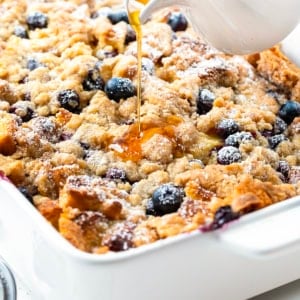 Pouring syrup over Blueberry Lemon French Toast Bake.