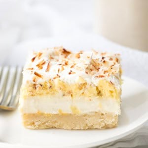 Coconut Cream Pie Bar on a white plate with a fork.