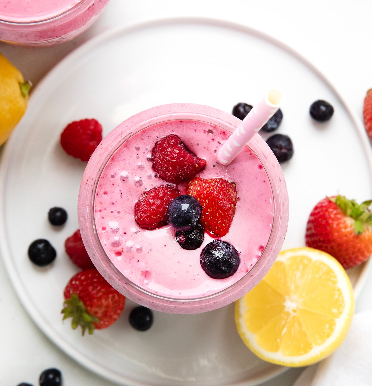 Looking down on a glass of Frosted Mixed Berry Lemonade with fruit on top.