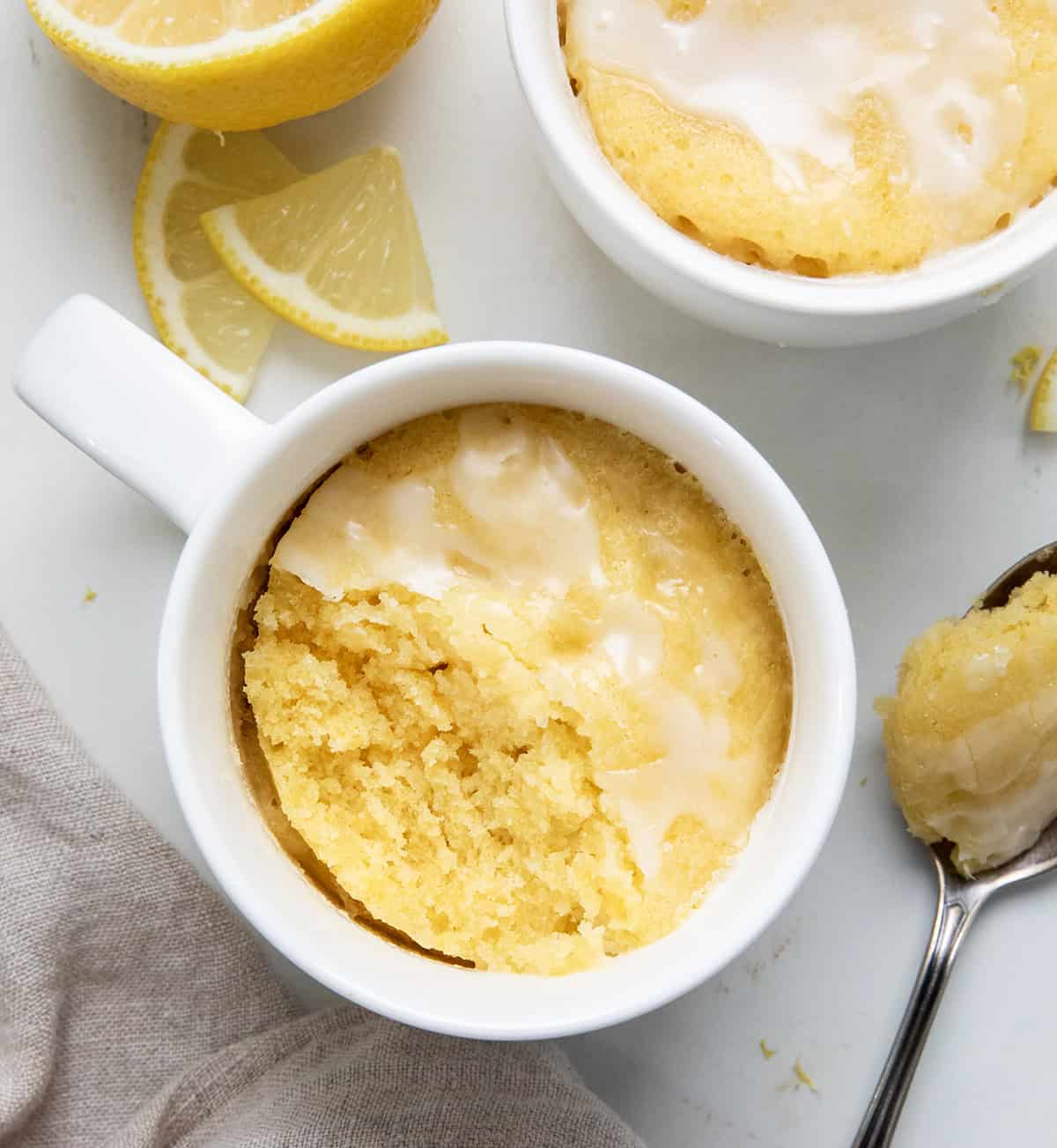 This Lemon Mug Cake is super easy and full of fresh, citrusy flavor. Itโs a quick mug cake recipe you can make in the microwave, perfect when you want a cozy single-serve dessert fast! Soft, sweet, and lemony, this lemon cake totally hits the spot! Lemon Mug Cake with a bite removed from overhead.