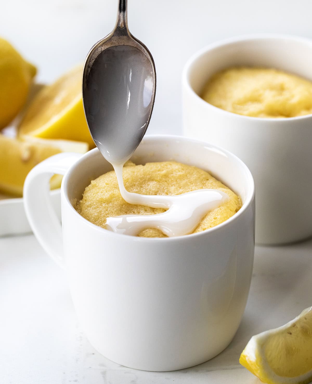This Lemon Mug Cake is super easy and full of fresh, citrusy flavor. Itโs a quick mug cake recipe you can make in the microwave, perfect when you want a cozy single-serve dessert fast! Soft, sweet, and lemony, this lemon cake totally hits the spot! Drizzling lemon glaze over Lemon Mug Cakes.