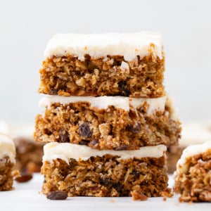 Stack of frosted Oatmeal Raisin Cookie Bars.
