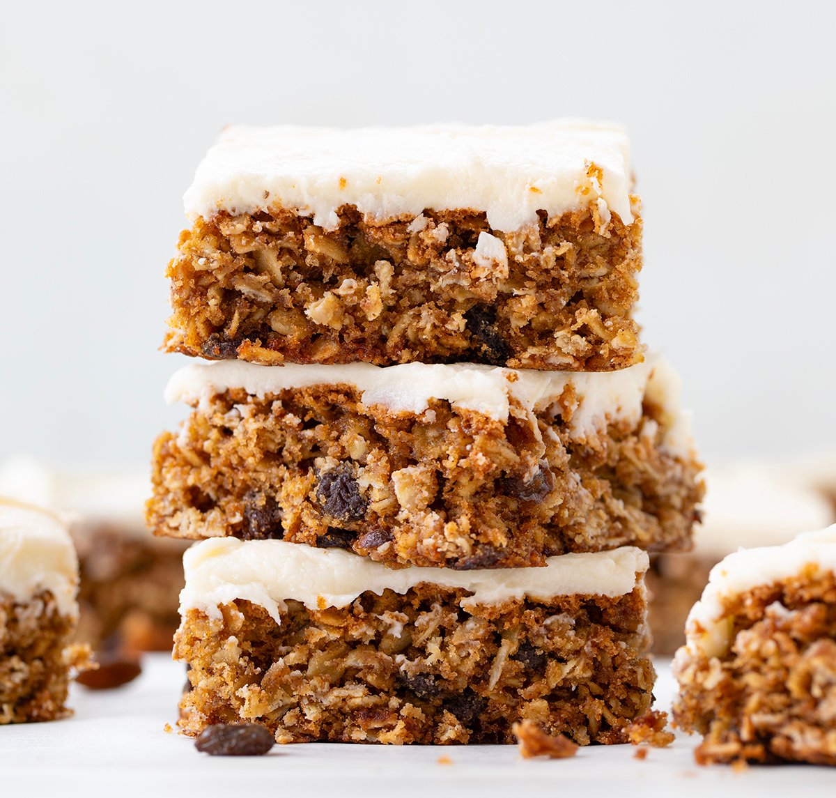 Stack of frosted Oatmeal Raisin Cookie Bars.