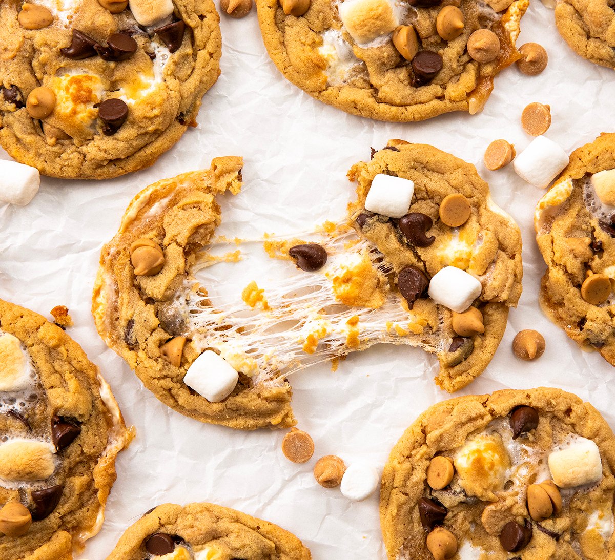 Soft, chewy peanut butter marshmallow cookies loaded with melty chocolate chips and gooey marshmallows. Easy, delicious, and perfect for any cookie lover! Split in half Peanut Butter Marshmallow Cookies where the marshmallow is gooey and stringy.