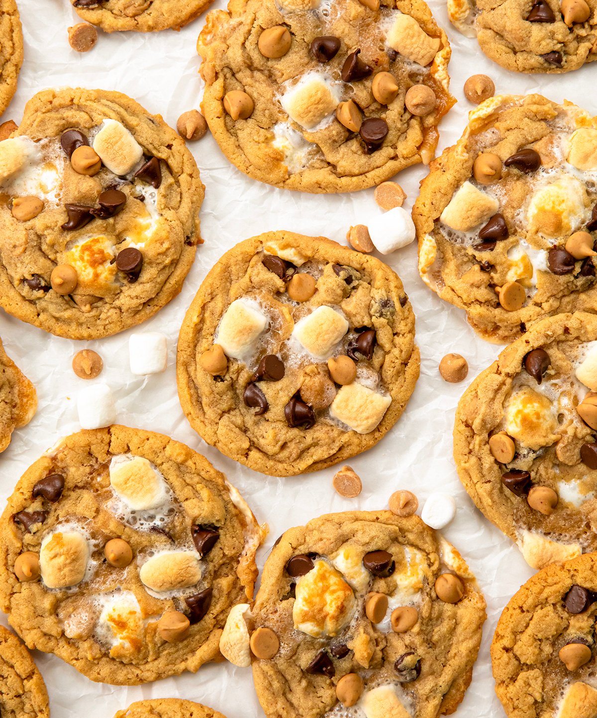 Soft, chewy peanut butter marshmallow cookies loaded with melty chocolate chips and gooey marshmallows. Easy, delicious, and perfect for any cookie lover! Peanut Butter Marshmallow Cookies on a white table from overhead.