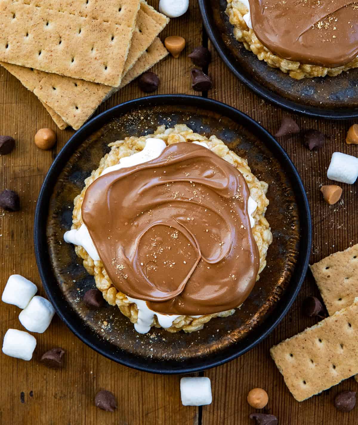 S'mores Scotcheroos on plates on a wooden table from overhead.