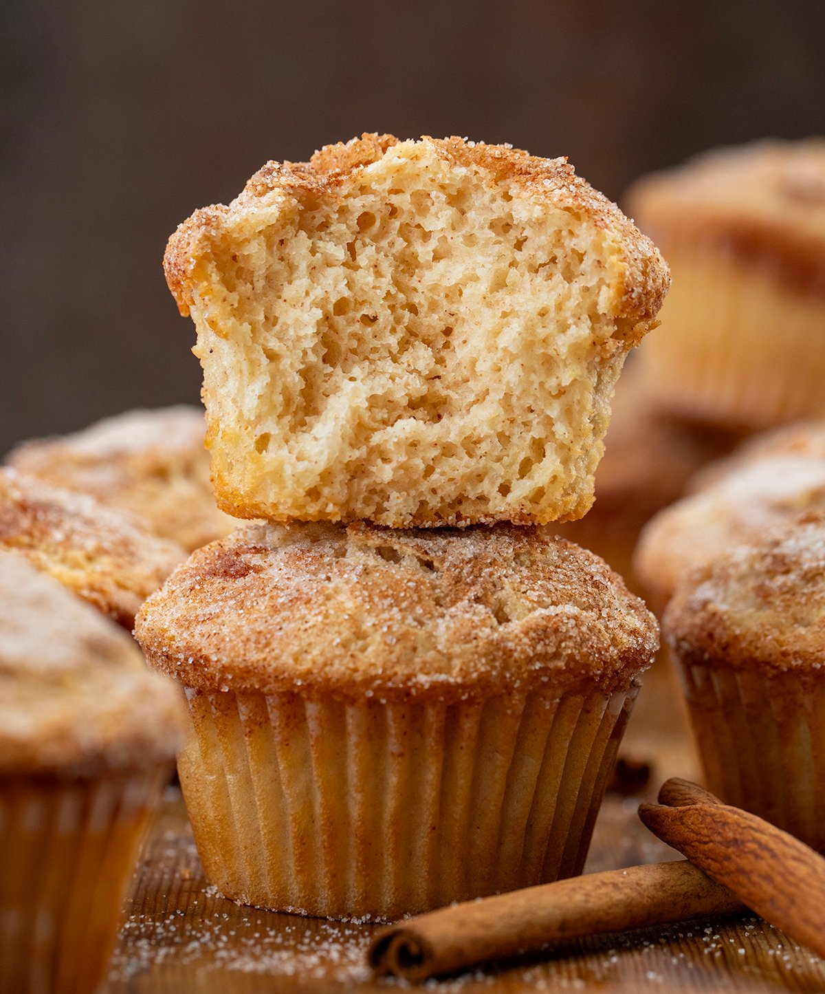 These Snickerdoodle Muffins are soft, tender cinnamon-sugar muffins with the classic tang from Snickerdoodle Cookies. They're inspired by my popular cinnamon sugar donut muffins but with that signature Snickerdoodle twist! Stack of Snickerdoodle Muffins with the top muffin cut in half showing inside texture.