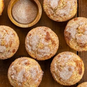 Snickerdoodle Muffins on a wooden table with cinnamon sugar from overhead.
