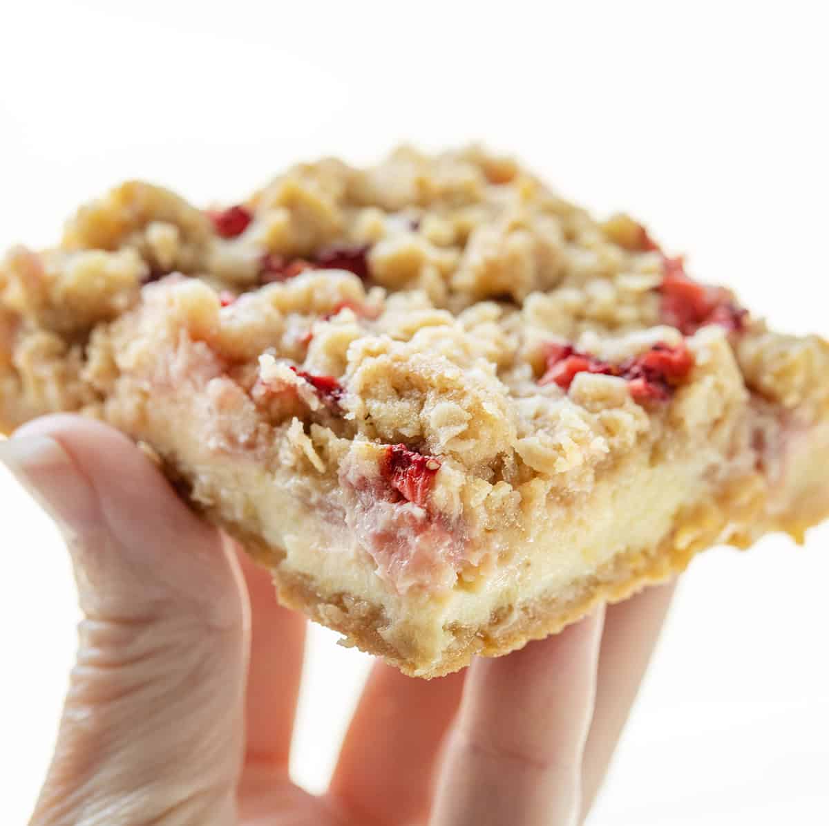 Hand holding one Strawberry Lemon Crumb Bar.
