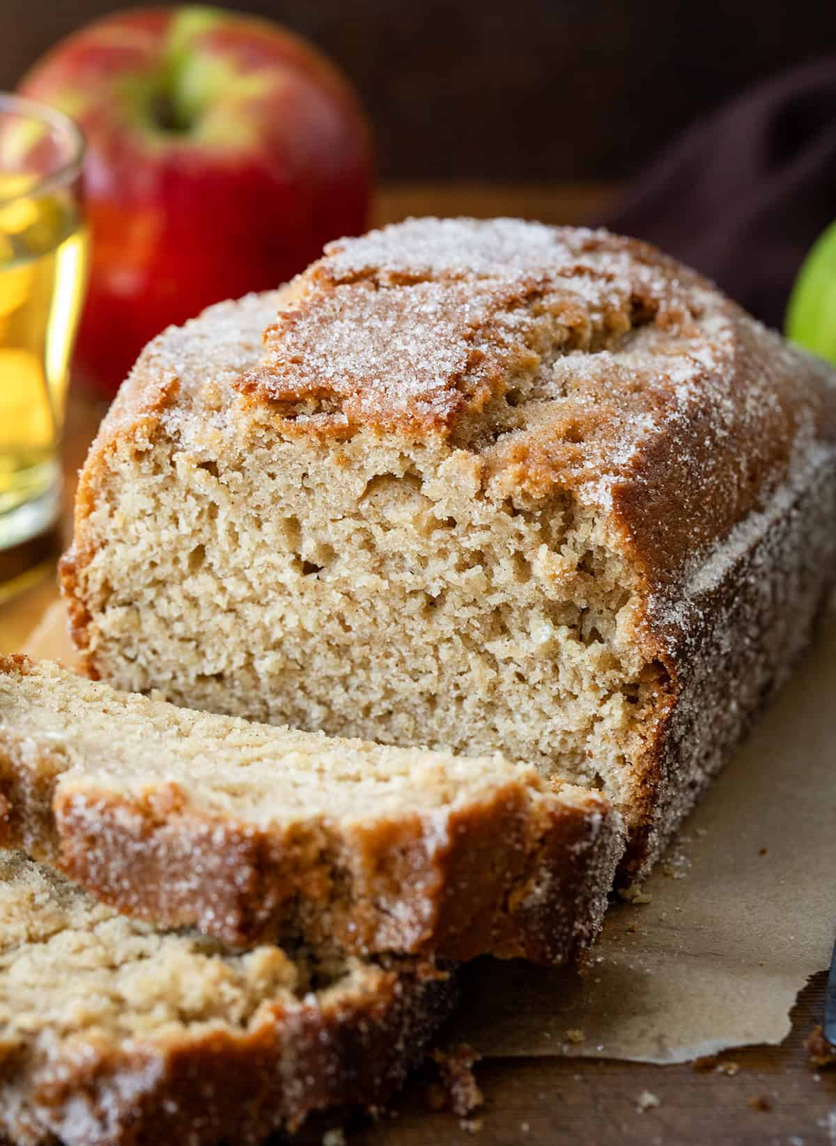 This Apple Cider Donut Bread is tender, cozy, and full of apple cider flavor, with warm apple pie spice in every bite. After baking, I pour apple cider over the warm loaf and sprinkle it with a cinnamon-sugar topping for that perfect “donut” finish... slightly crisp on the outside, soft and moist inside! Close up of Apple Cider Donut Bread that has been cut into with pieces falling.