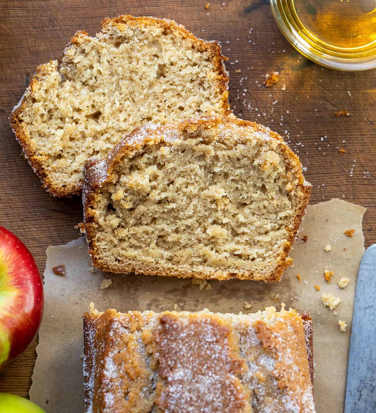 This Apple Cider Donut Bread is tender, cozy, and full of apple cider flavor, with warm apple pie spice in every bite. After baking, I pour apple cider over the warm loaf and sprinkle it with a cinnamon-sugar topping for that perfect “donut” finish... slightly crisp on the outside, soft and moist inside! Looking down on cut into loaf of Apple Cider Donut Bread with the focus on two pieces.