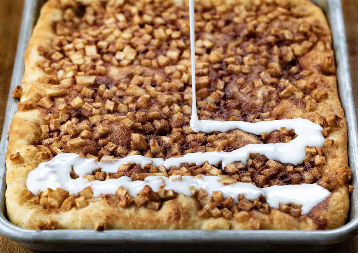 Drizzling glaze over Apple Fritter Focaccia bread.
