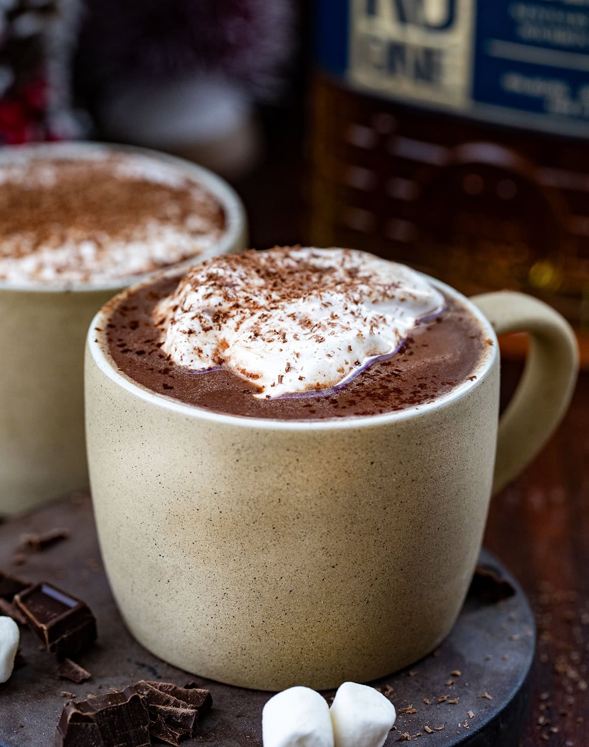 Close up of mugs of Bad Santa Hot Chocolate topped with whipped cream and shaved chocolate.