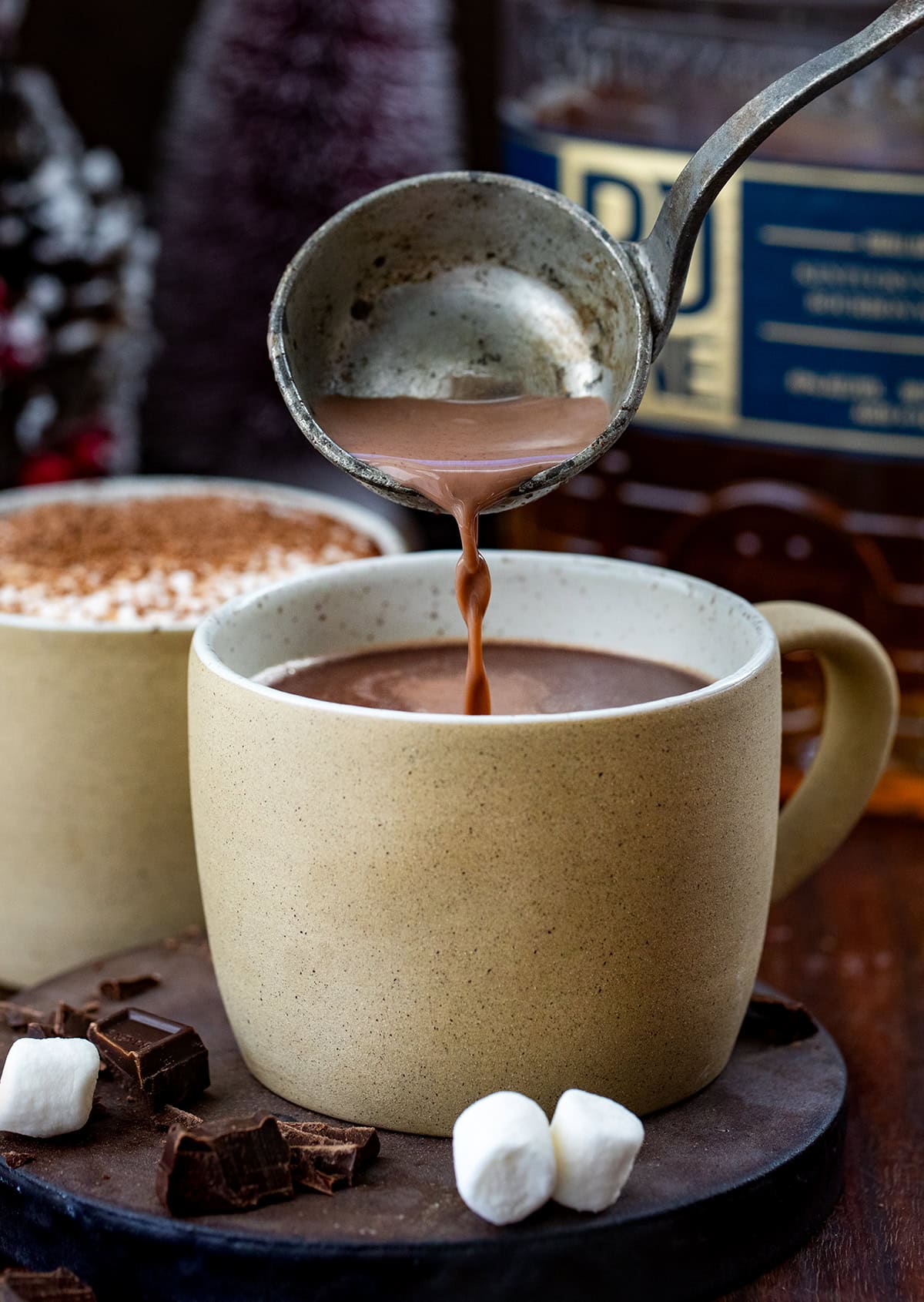 Pouring bourbon hot chocolate into a mug.