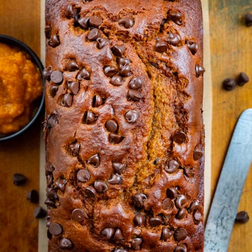 Loaf of Chocolate Chip Pumpkin Bread on a wooden table from overhead.