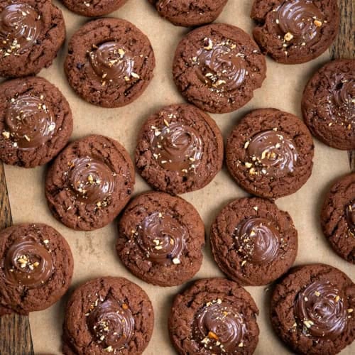 Chocolate Hazelnut Thumbprint Cookies on a wooden table from overhead.