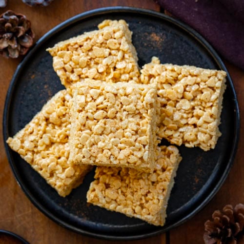 Black plate of Gingerbread Rice Krispie Treats stacked from overhead.