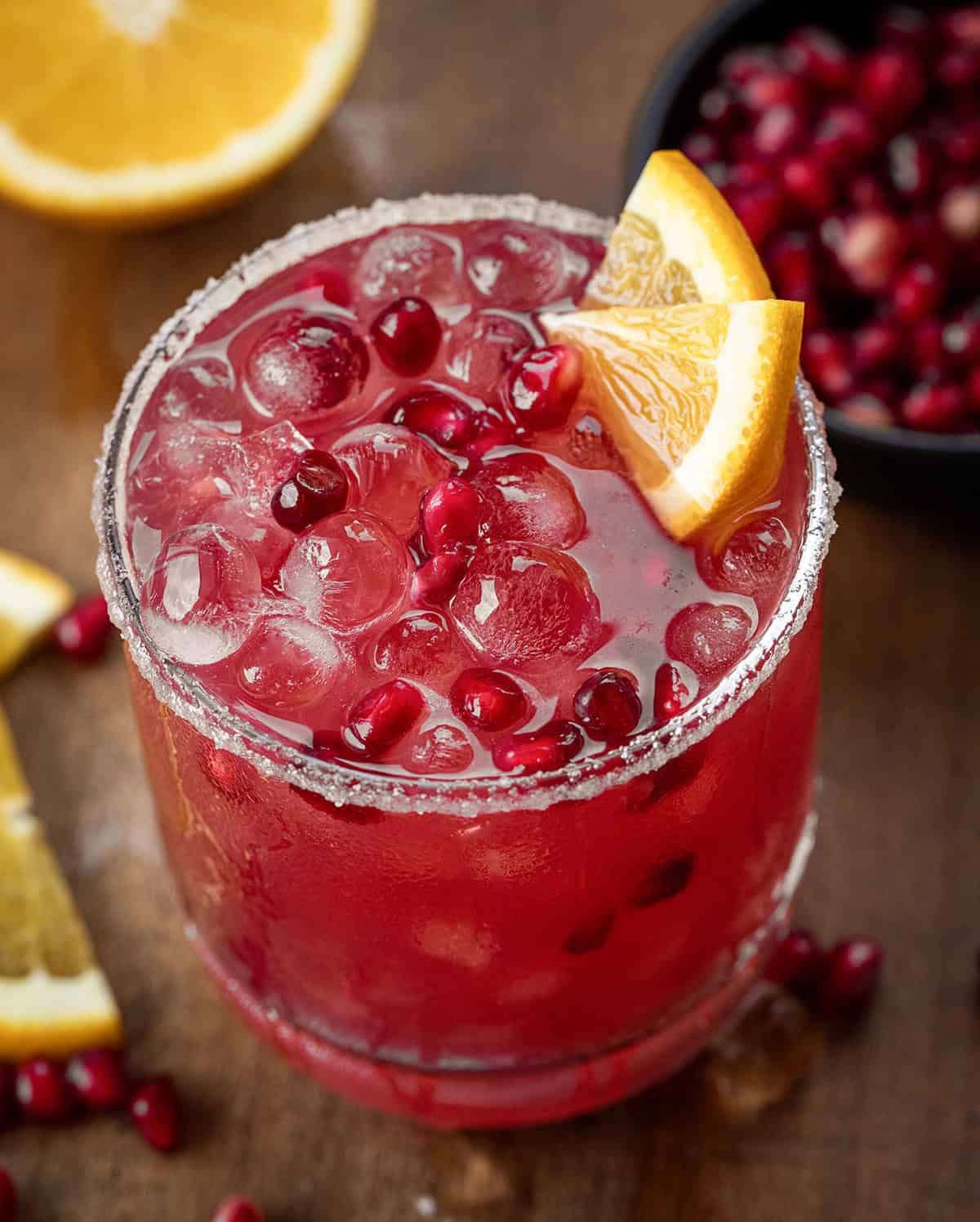 Very close of a glass of Orange Pomegranate Margarita with a sugar rim.