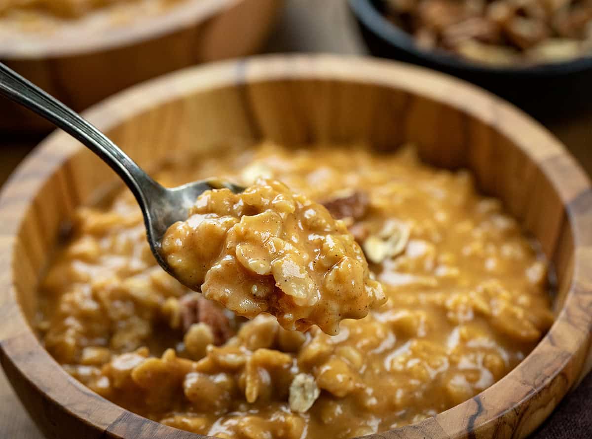 Bowl of Pumpkin Spice Oatmeal with a spoon filled held above it.
