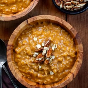 Bowls of Pumpkin Spice Oatmeal on a wooden table from overhead.
