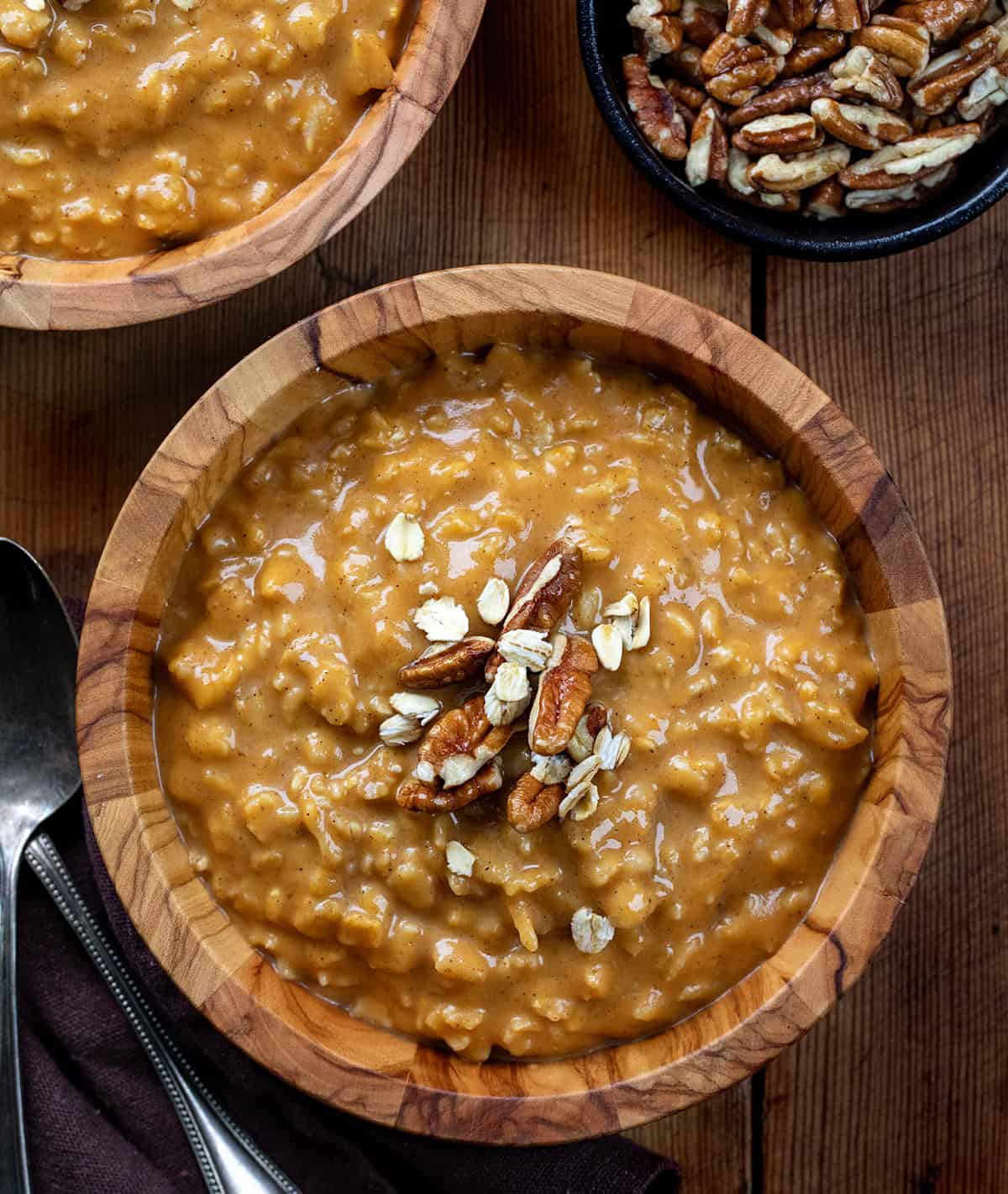 Bowls of Pumpkin Spice Oatmeal on a wooden table from overhead.