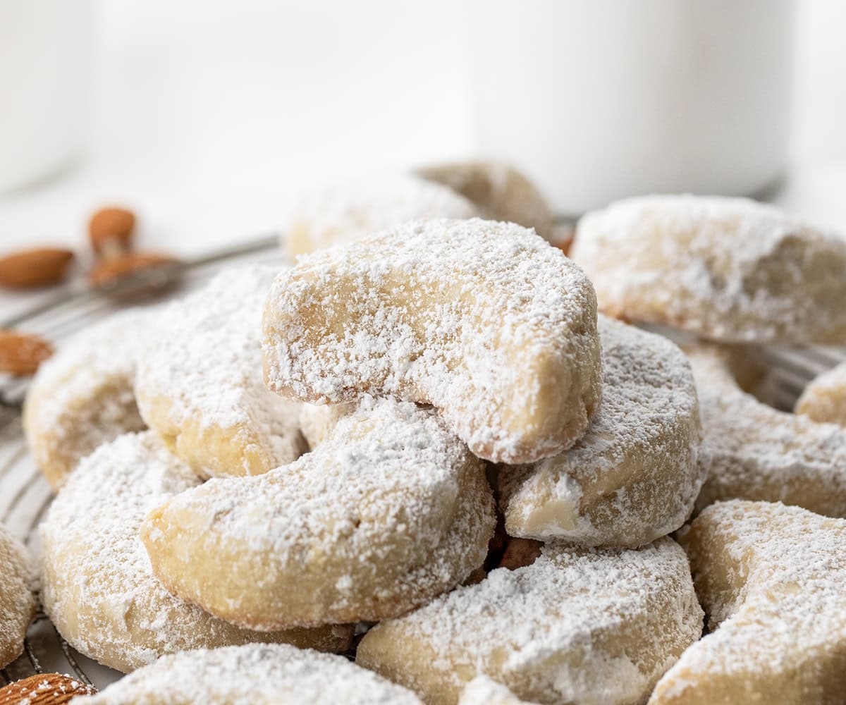 There’s something magical about these delicate almond crescent cookies. They’re buttery, tender, and melt-in-your-mouth soft, with just the right dusting of sweet confectioners’ sugar! Close up of Almond Crescent Cookies.