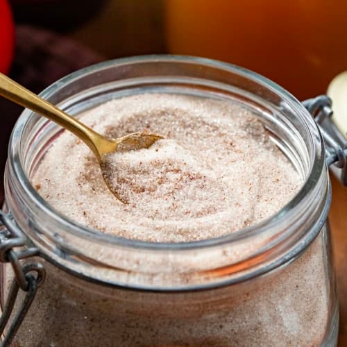 Jar with Apple Cider Mix and a gold spoon in it.