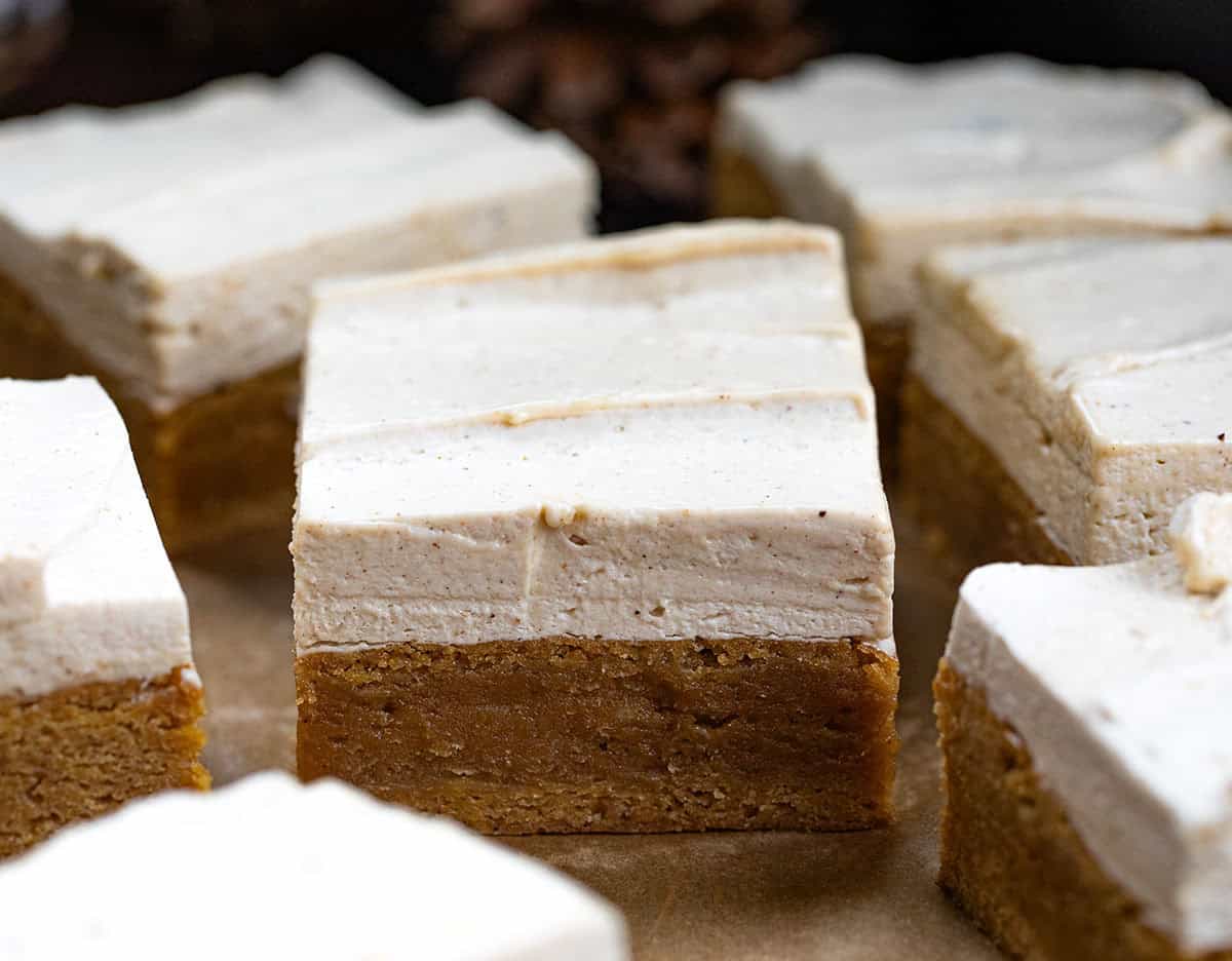 These Frosted Gingerbread Brownies start with my beloved gingerbread brownie base and get a decadent upgrade with a creamy gingerbread ermine frosting. The brownies are soft, tender, and perfectly spiced, while the frosting adds a silky, sweet layer that melts in your mouth! Close up of Frosted Gingerbread Brownies cut into squares and separated slightly.