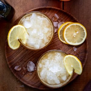 Looking down at glasses of Maple Whiskey Sour on a wooden table.