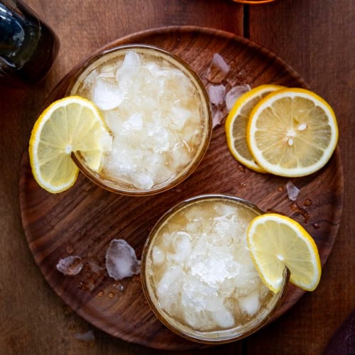 Looking down at glasses of Maple Whiskey Sour on a wooden table.