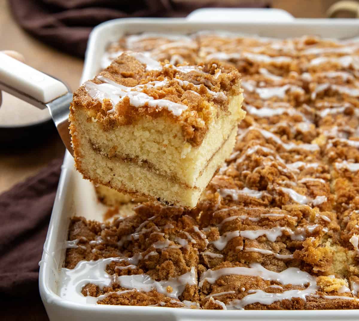 If you love snickerdoodles, wait until you try them in coffee cake form! This Snickerdoodle Coffee Cake combines the buttery cinnamon-sugar goodness of the classic cookie with a soft, tender cinnamon coffee cake! Spatula picking up a piece of Snickerdoodle Coffee Cake.