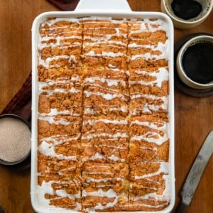 Pan of Snickerdoodle Coffee Cake on a wooden table from overhead with coffee cups.
