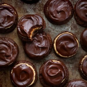 Buckeye Cookies on a dark surface with one cookie bit into.