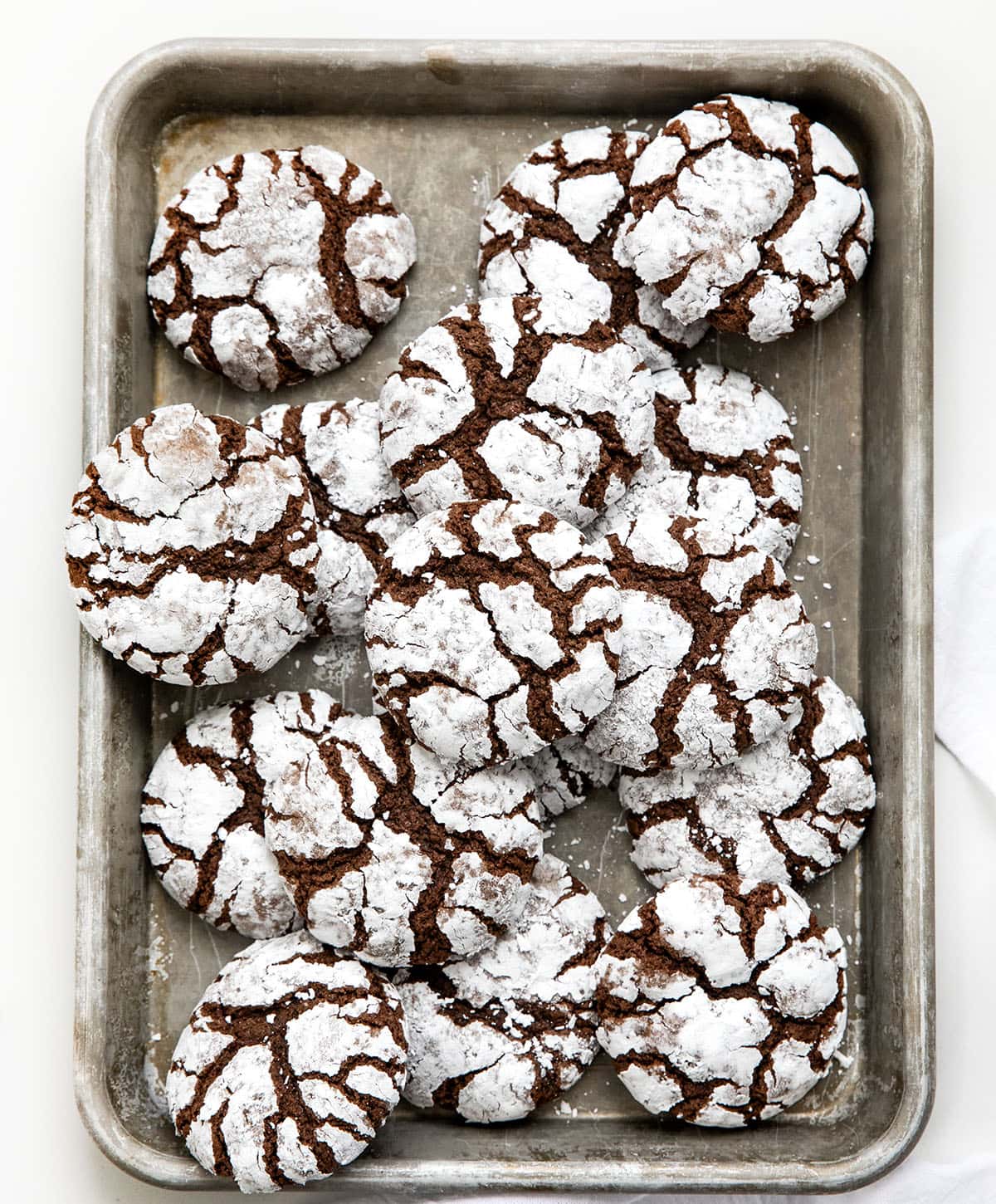 Sheet pan of Chocolate Peppermint Crinkle Cookies on a white table from overhead. 