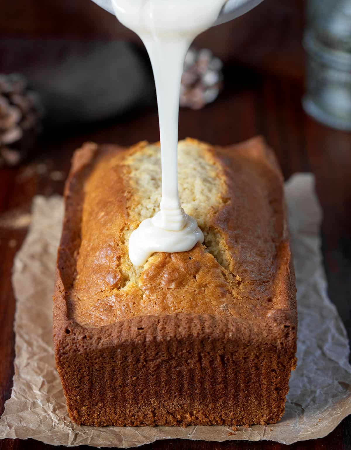 Pouring eggnog glaze over Eggnog Bread.