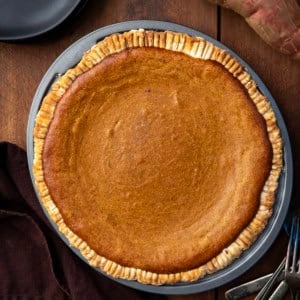 Whole Roasted Sweet Potato Pie on a wooden table from overhead.