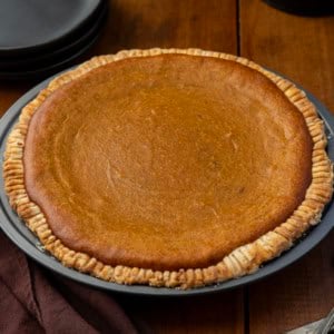 Whole Roasted Sweet Potato Pie on a wooden table.