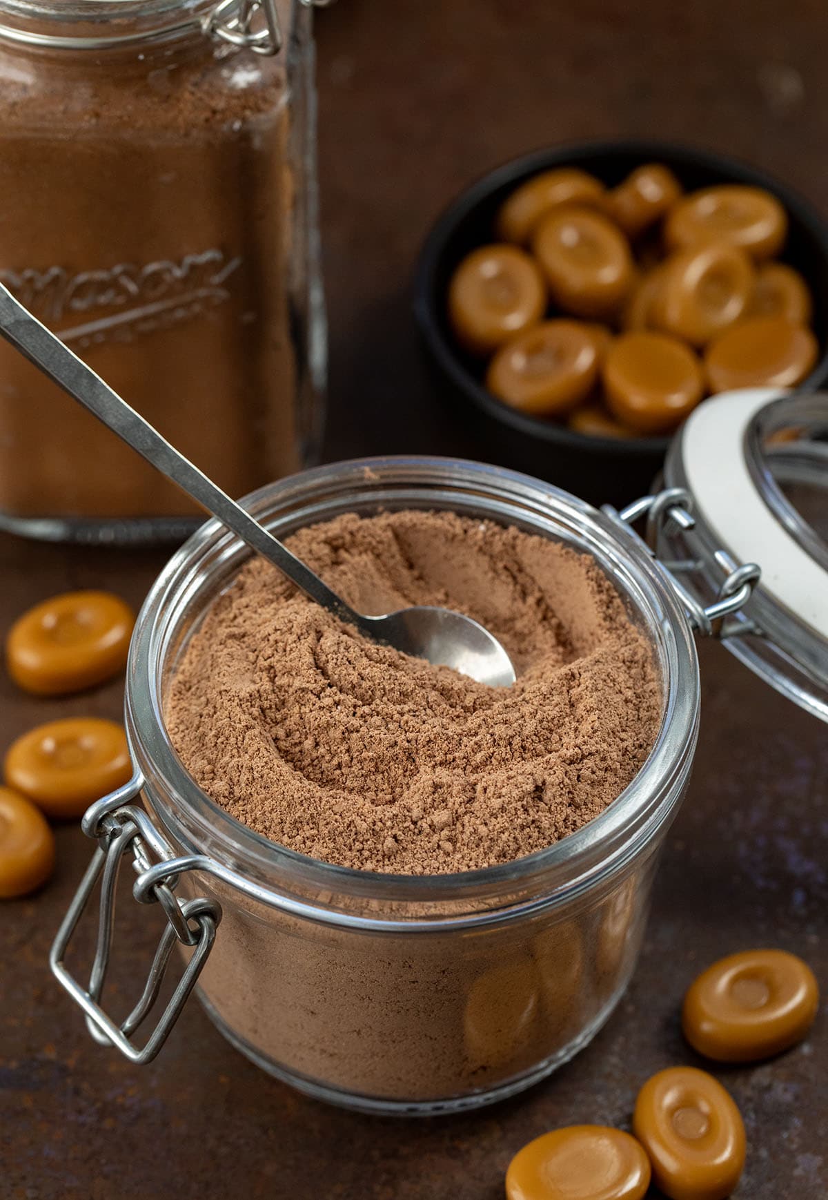 Container of Salted Caramel Hot Cocoa Mix with a spoon in it.