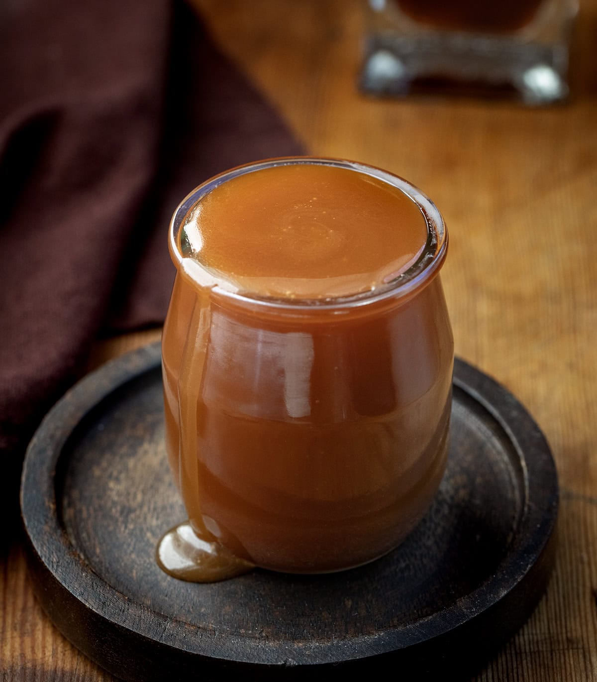 Rich, buttery, and boozy in the best way, this Bourbon Caramel Sauce takes classic caramel to the next level. Itโs sweet, slightly smoky, and full of deep, warm flavor thanks to a splash of bourbon! Glass jar filled with Bourbon Caramel Sauce on a wooden table.