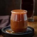 Bourbon Caramel Sauce spilling over a glass jar.