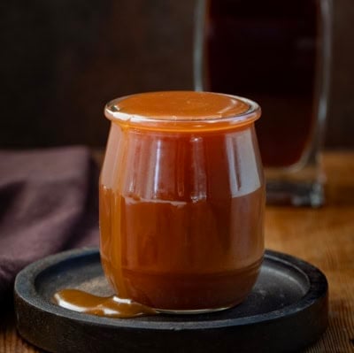 Bourbon Caramel Sauce spilling over a glass jar.