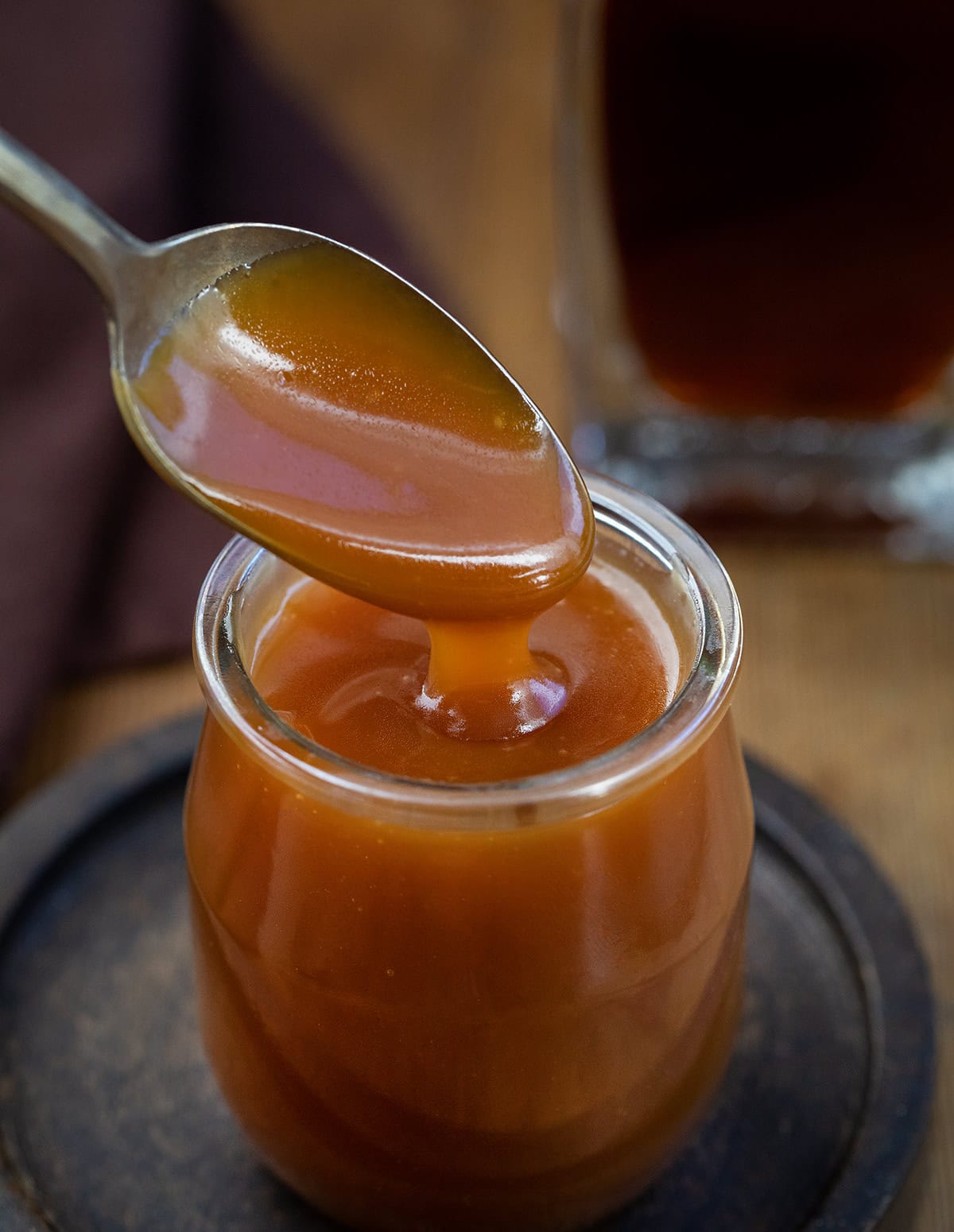 Rich, buttery, and boozy in the best way, this Bourbon Caramel Sauce takes classic caramel to the next level. Itโs sweet, slightly smoky, and full of deep, warm flavor thanks to a splash of bourbon! Spoonful of Bourbon Caramel Sauce being held above the jar.