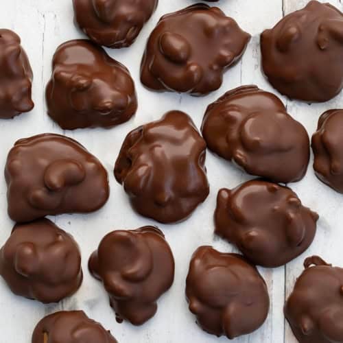Chocolate Caramel Cashew Clusters on a white table from overhead.