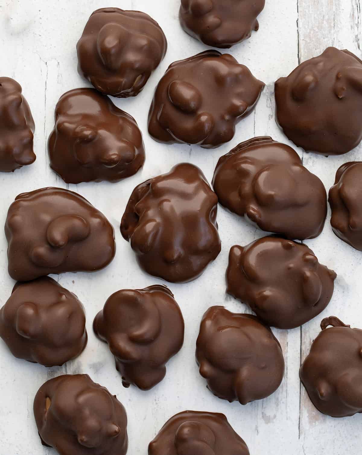 Chocolate Caramel Cashew Clusters on a white table from overhead.