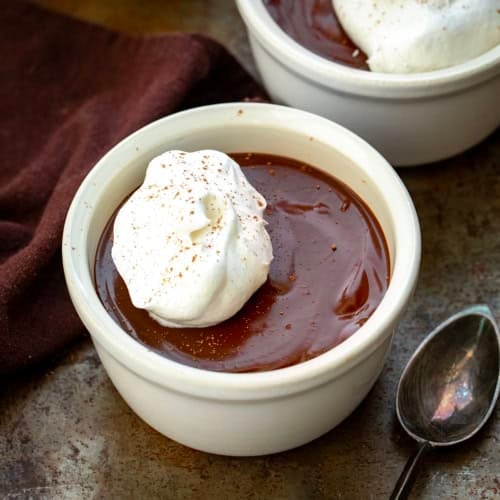 Close up of white Chocolate Pots De Crème with a spoon.