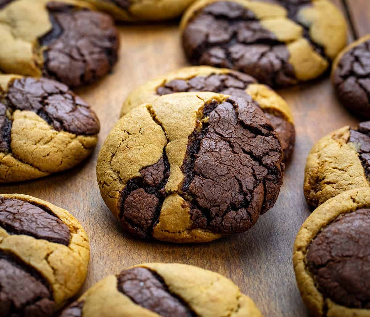Ginger Brownie Cookies on a wooden table laid out and one cookie is resting on another.