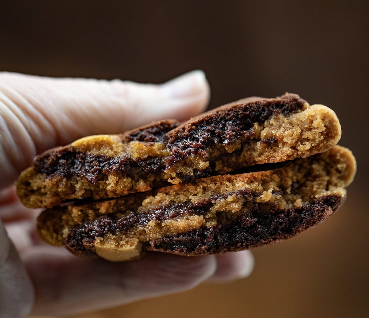 Hand holding a halved Ginger Brownie Cookie.